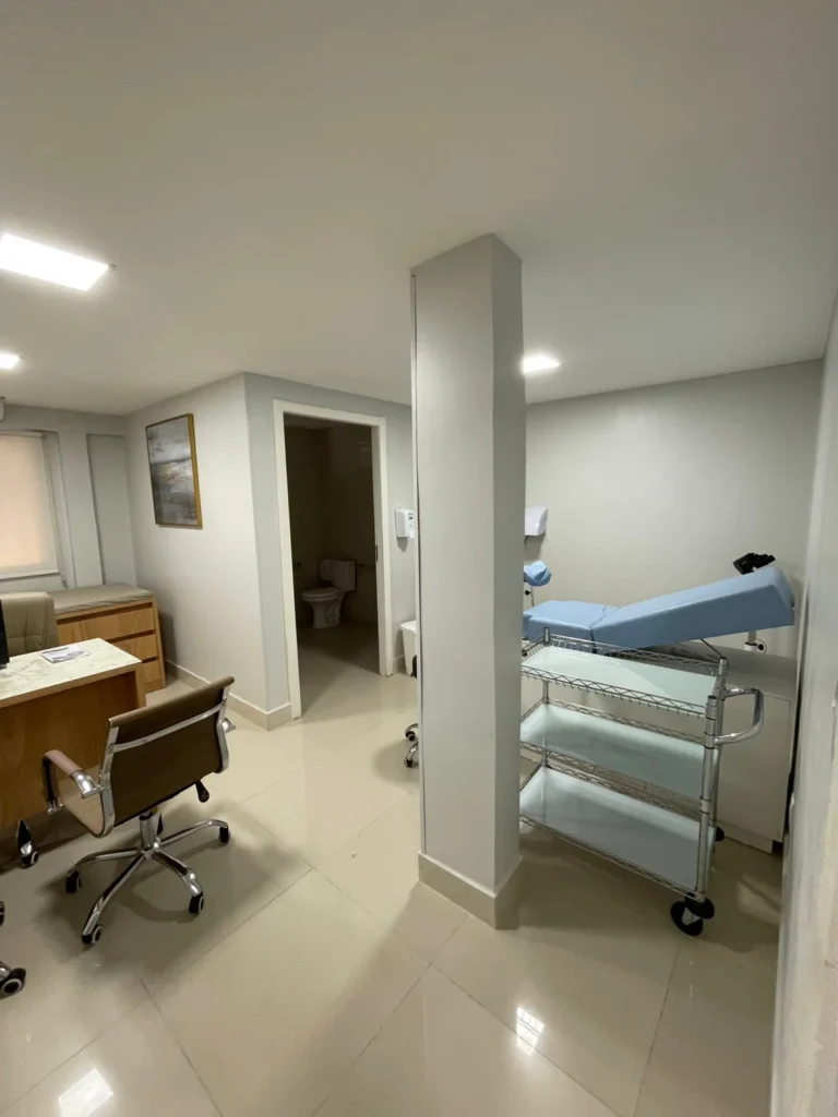 Consultório da Riosmed com mesa e maca de atendimento.