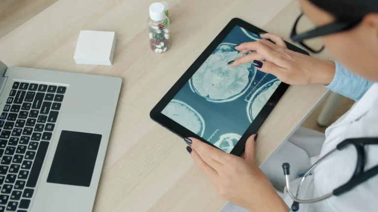 Profissional analisando imagens do cérebro em um tablet, em fotografia ilustrativa.